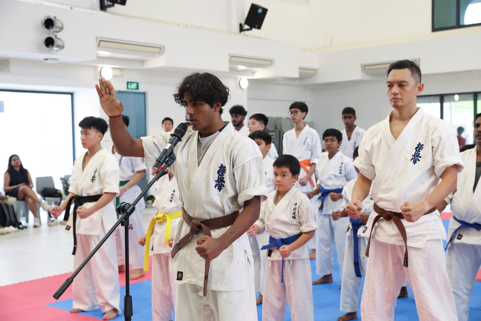 Karateka leading the dojo oath with raised hand