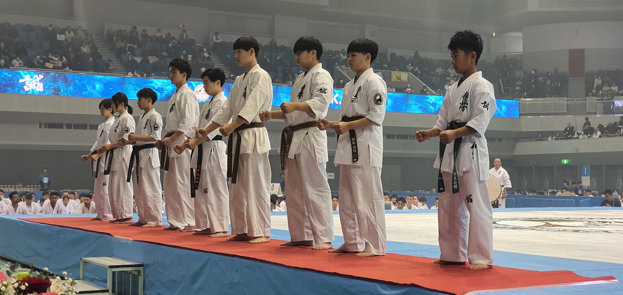 Young karateka lined up in seishin at a tournament opening ceremony